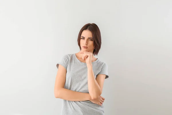 Beautiful thoughtful young woman on grey background — Stock Photo, Image