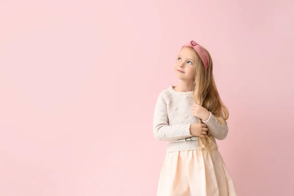 Милая маленькая девочка в осенней одежде на цветном фоне — стоковое фото