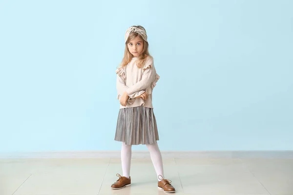 Cute little girl in autumn clothes near color wall — Stock Photo, Image