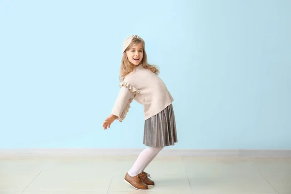 Roztomilé holčička v podzimním oblečení v blízkosti barevné stěny — Stock fotografie