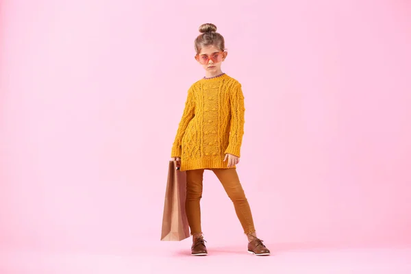 漂亮的小女孩，穿着秋天的衣服，背着色彩斑斓的购物袋 — 图库照片