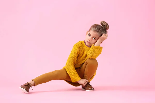 Nettes kleines Mädchen in Herbstkleidung auf farbigem Hintergrund — Stockfoto