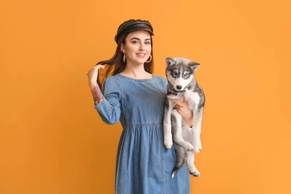 Stylish woman with funny husky puppy on color background — Stock Photo, Image