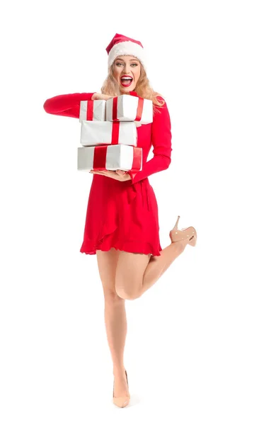 Schöne junge Frau in Weihnachtsmütze und mit Weihnachtsgeschenken auf weißem Hintergrund — Stockfoto