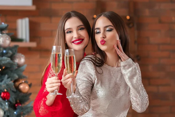 Schöne junge Frauen mit Champagner, die zu Hause Weihnachten feiern — Stockfoto