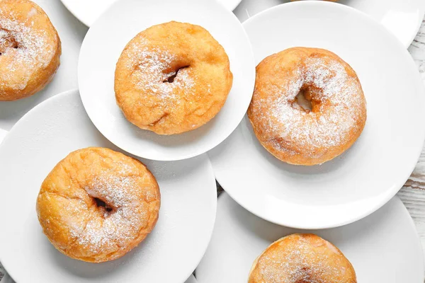 Platen met zoete lekkere donuts op tafel — Stockfoto