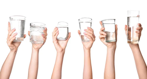 Mãos femininas com copos de água no fundo branco — Fotografia de Stock