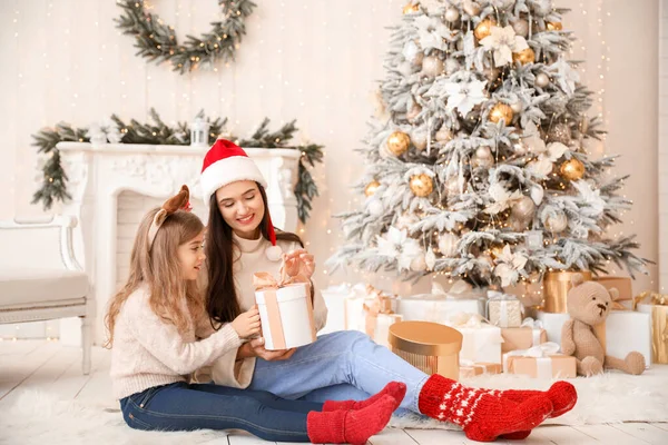 Happy mother and little daughter opening Christmas gift at home — Stock Photo, Image