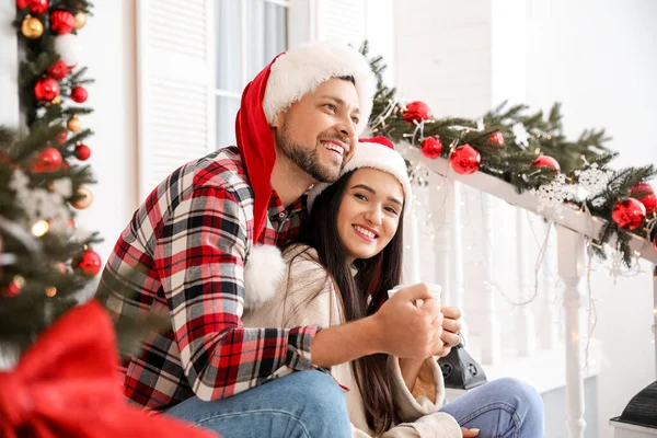 Happy couple drinking tea on porch decorated for Christmas — Stock Photo, Image