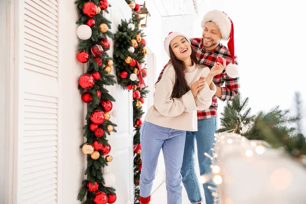 Szczęśliwa para dekorowanie ganek na Boże Narodzenie — Zdjęcie stockowe