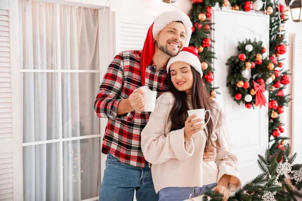 Happy couple drinking tea on porch decorated for Christmas — Stock Photo, Image