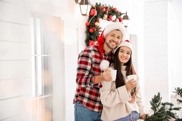 Happy couple drinking tea on porch decorated for Christmas — Stock Photo, Image