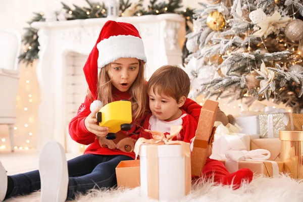 Små barn öppnar julklappar hemma — Stockfoto