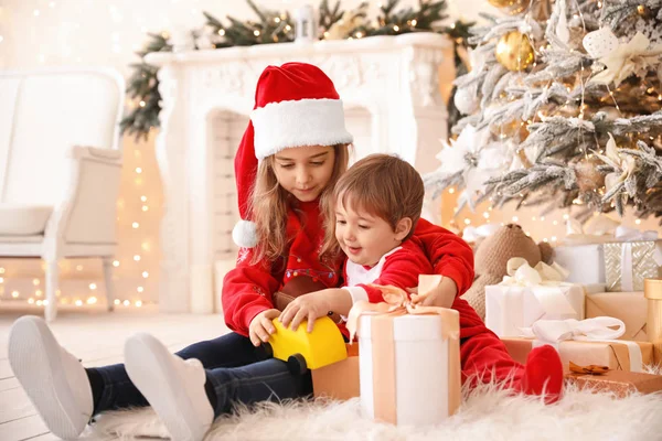 Små barn öppnar julklappar hemma — Stockfoto