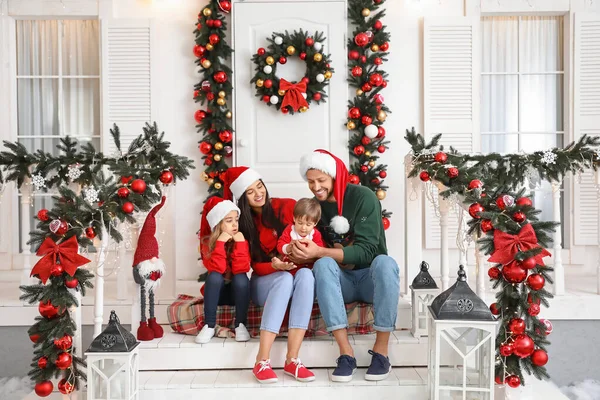 Família feliz sentado no alpendre decorado para o Natal — Fotografia de Stock