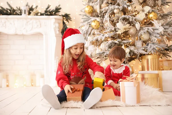 Kleine kinderen die thuis kerstcadeaus openen — Stockfoto