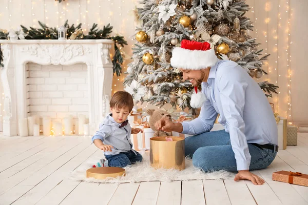 Pai feliz com o pequeno filho abrindo presente de Natal em casa — Fotografia de Stock