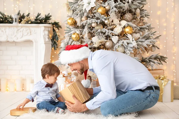 Happy father with little son opening Christmas gift at home — Stock Photo, Image