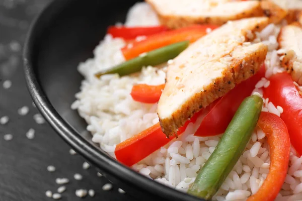Bowl with tasty rice, chicken and vegetables, closeup Stock Photo