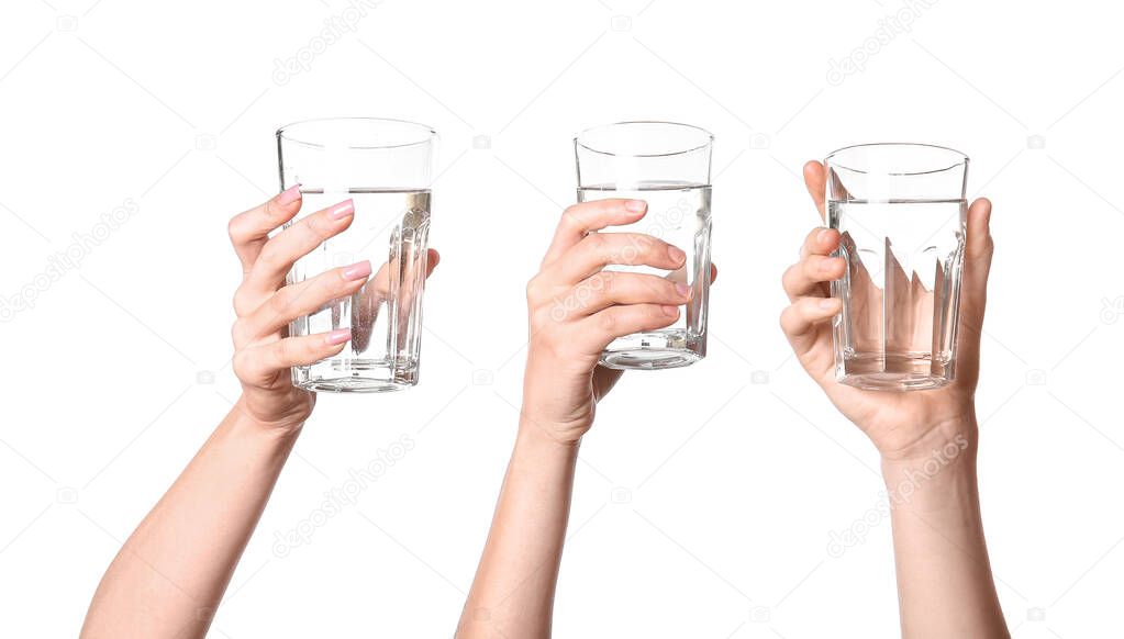 Female hands with glasses of water on white background