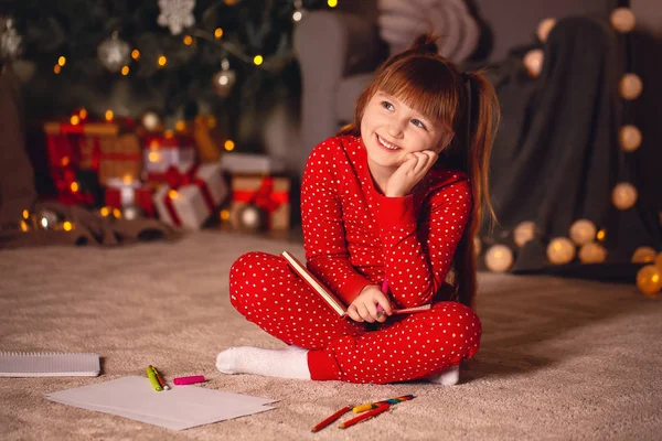 Nettes kleines Mädchen schreibt an Heiligabend Brief an den Weihnachtsmann zu Hause — Stockfoto