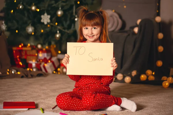 Nettes kleines Mädchen mit Brief an den Weihnachtsmann an Heiligabend zu Hause — Stockfoto