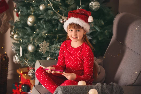 Bonita menina escrevendo carta para o Papai Noel na véspera de Natal em casa — Fotografia de Stock