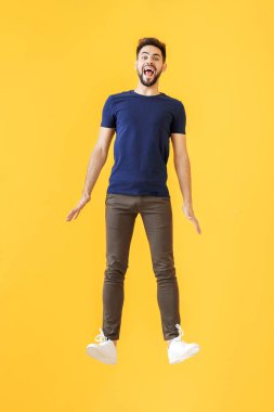 Renkli arka planda zıplayan genç adam