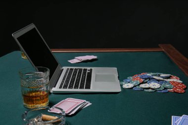 Kumarhanede kart ve poker fişleri olan dizüstü bilgisayar.