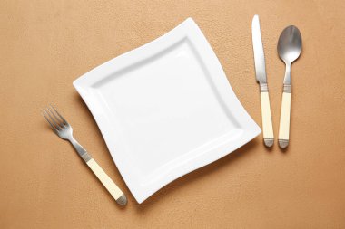 Arkaplanda boş tabak ve çatal bıçak takımı