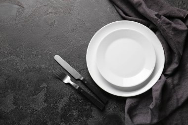 Koyu arkaplanda boş tabak ve çatal bıçak takımı