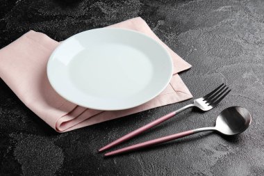 Koyu arkaplanda boş tabak ve çatal bıçak takımı