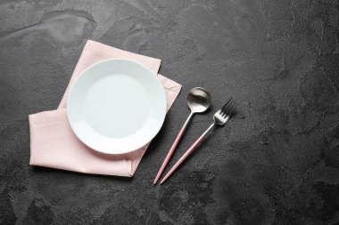 Koyu arkaplanda boş tabak ve çatal bıçak takımı