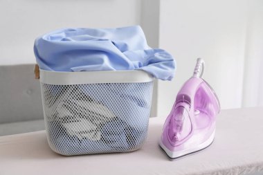 Demir ve temiz giysiler odada sepette.