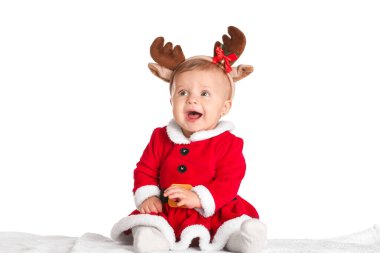 Noel Baba kostümlü şirin bir bebek ve beyaz arka planda geyik boynuzları.