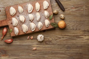 Ahşap zemin üzerinde çiğ hamur köftesi ve malzeme olan tahta.