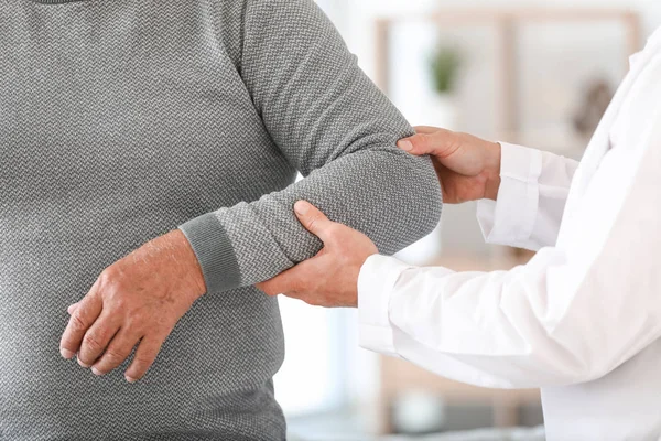 Arzt untersucht reifen Mann mit Gelenkschmerzen zu Hause, Nahaufnahme — Stockfoto