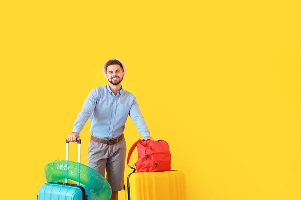 Giovane turista maschio con bagagli su sfondo a colori — Foto Stock