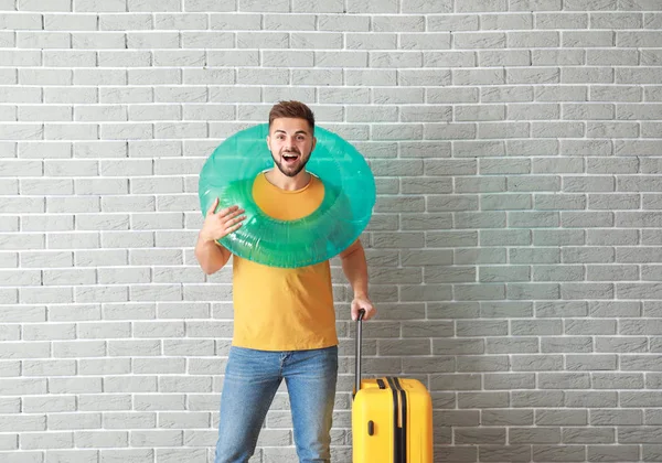 Junge männliche Touristin mit Gepäck nahe Ziegelmauer — Stockfoto