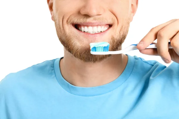 Jovem escovar os dentes no fundo branco, close-up — Fotografia de Stock