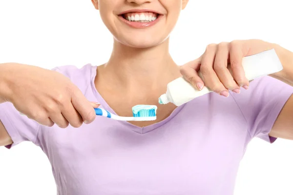 Молода жінка з зубною щіткою і пастою на білому тлі — стокове фото