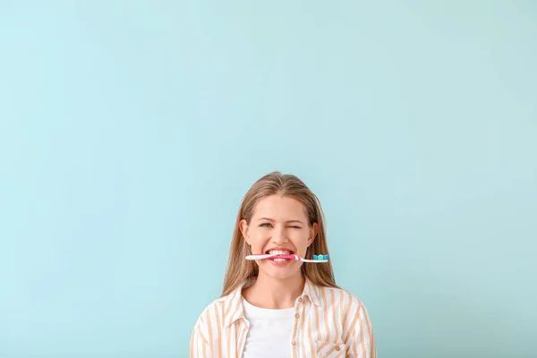 Young woman with toothbrush on color background — Stock Photo, Image