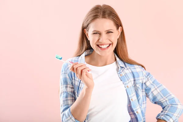 Young woman with toothbrush on color background — Stock Photo, Image