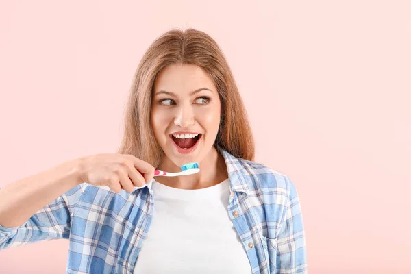 Mladá žena čištění zubů na barevném pozadí — Stock fotografie