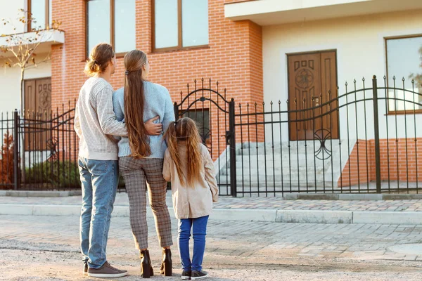 Família jovem perto de sua nova casa — Fotografia de Stock
