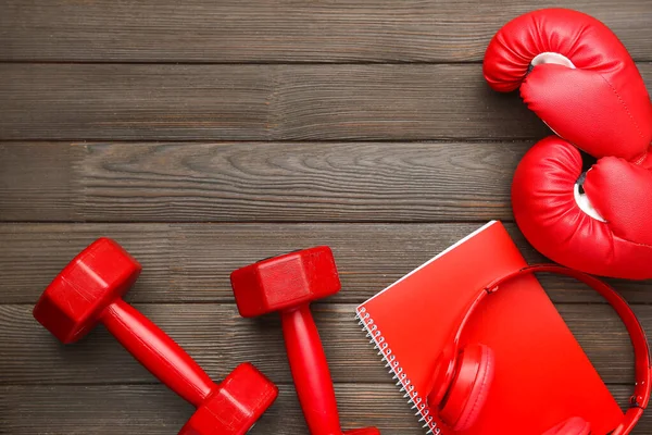 Sombrillas con cuaderno, guantes de boxeo y auriculares sobre fondo de madera — Foto de Stock