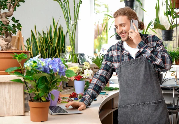 Florist taking order by phone in shop — Stock Photo, Image