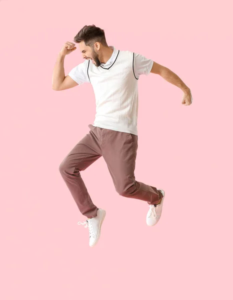 Jumping young man on color background — Stock Photo, Image