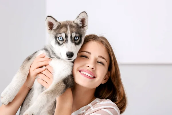 Cute teenage girl with funny husky puppy at home — Stock Photo, Image