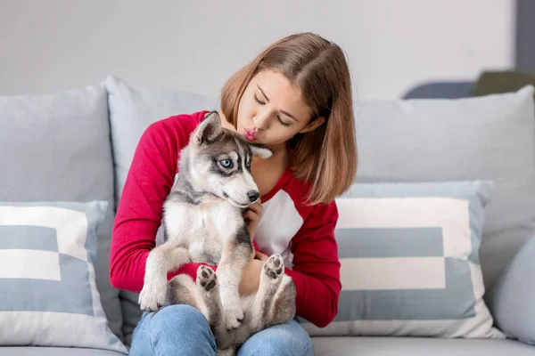 Linda chica adolescente con divertido husky cachorro en casa — Foto de Stock